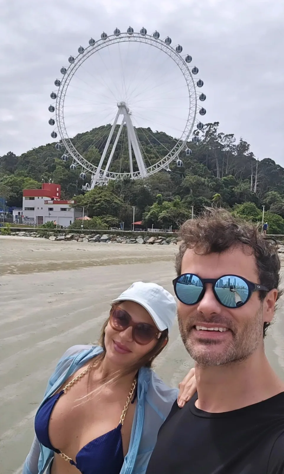 Ju e Vini na areia, com a roda-gigante de BC ao fundo